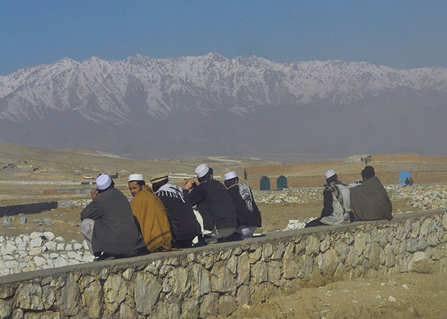 Afghan men sitting on a wall