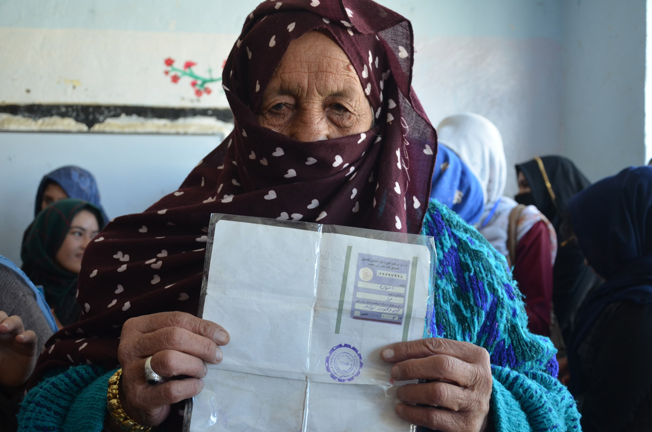 A woman at a Bamyan polling station displays her tazkera with its registration sticker affixed to the back as she prepares to vote in a parliamentary election, October 20, 2018. DOD photo