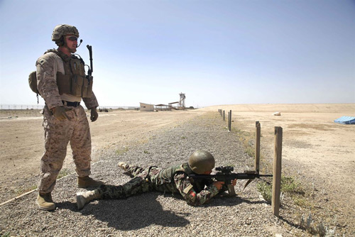 A U.S. Marine observes an ANA soldier at the Helmand Regional Military Training Center at Camp Shorabak. The U.S. Marine Corps was forced to redeploy to Helmand following the collapse of the ANA 215th Corps in 2015. (U.S. Marine Corps photo by Lucas Hopkins)