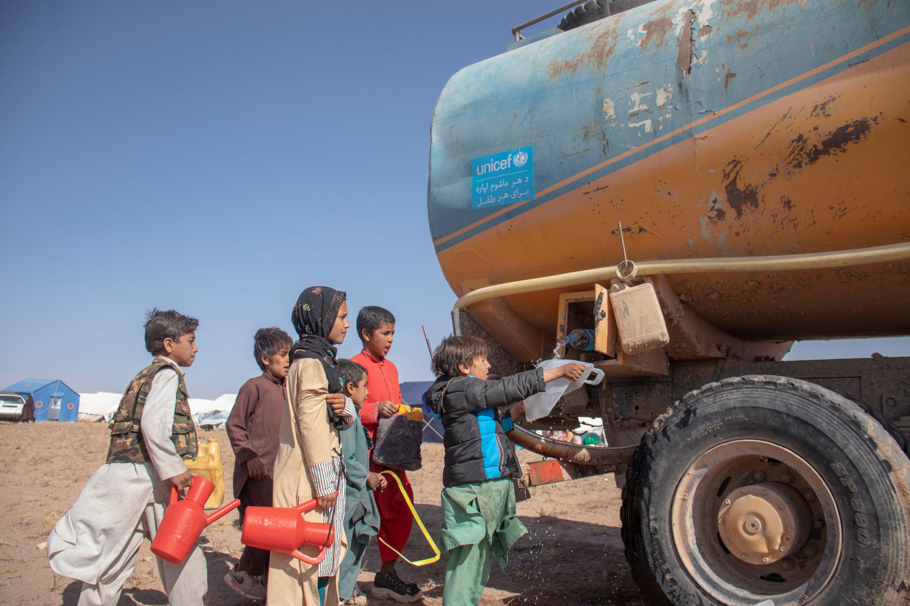 Children get water from a UNICEF truck in Herat Province following several earthquakes in October. (UNICEF photo/Osman Khayyam)