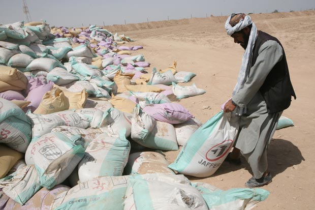 A farmer takes a bag of fertilizer at the Civil-Military Operations Center at Camp Hansen in Marjah District, Helmand Province, on April 25, 2010. (Marine Corps photo)